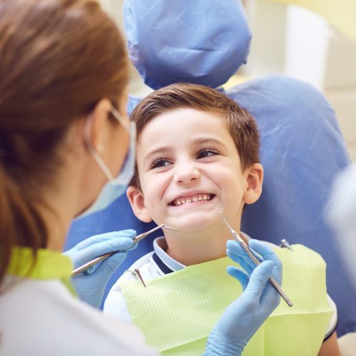 A child with a dentist in a dental office. Dental treatment in a children's clinic.